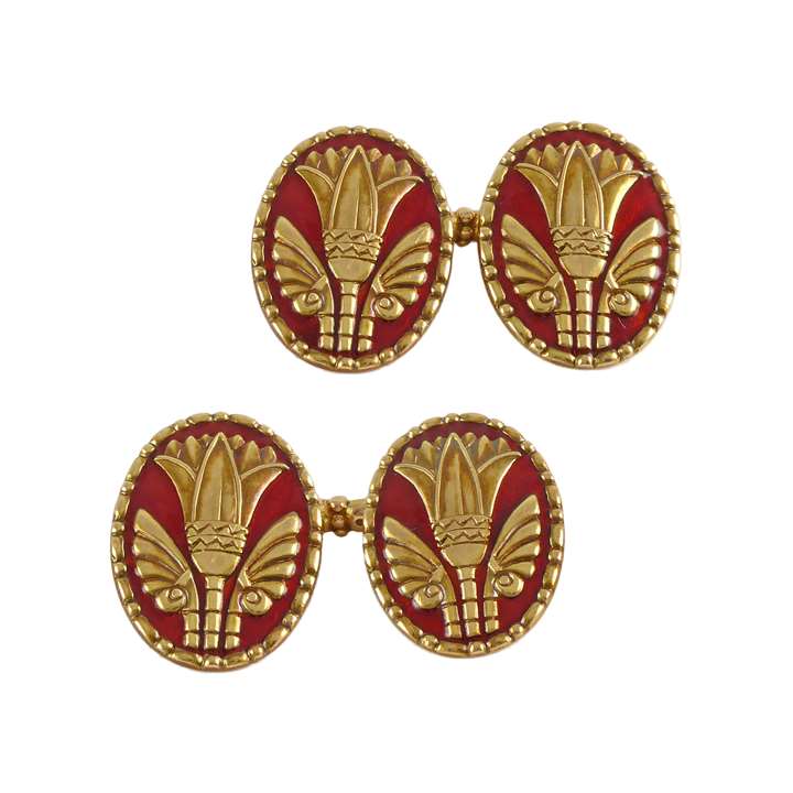 Pair of early 20th century gold and enamel cufflinks by Marcus & Co, New York, the oval faces embossed with an Egyptianesque lotus set against a red enamel background,